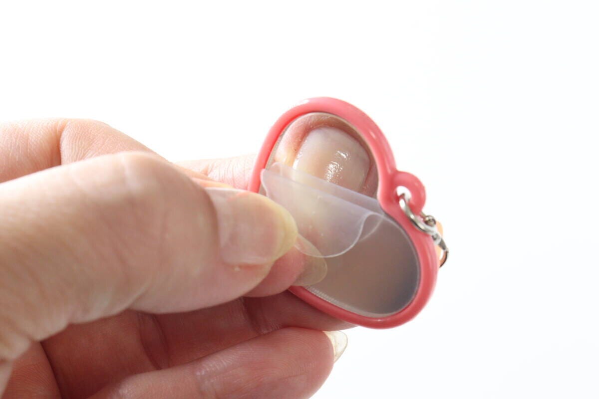 リップミラーの鏡の保護フィルムを剥がす手元 リップミラーの鏡の保護フィルムを剥がす手元