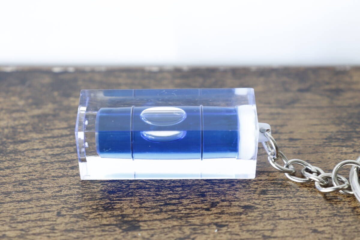木目調の台に置かれたキーホルダー水平器を横から撮影