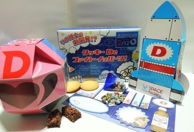 オープンを記念して各種グッズも販売しています。左から、リポビタンマン チョコクランチ650円(15個入り)、クッキーDeファイト イッパーツ!540円(12枚中2枚激辛クッキーあり)、リポビタンロケットチョコ500円(9袋入り)。手前はSPACE factory 付箋セット500円