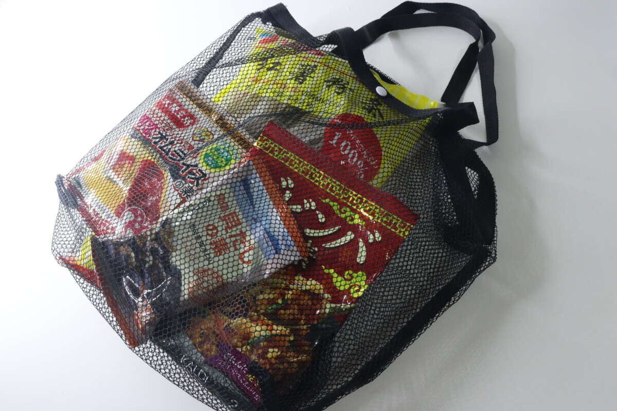 メッシュバッグにお菓子や乾物などの食料品が複数入っている