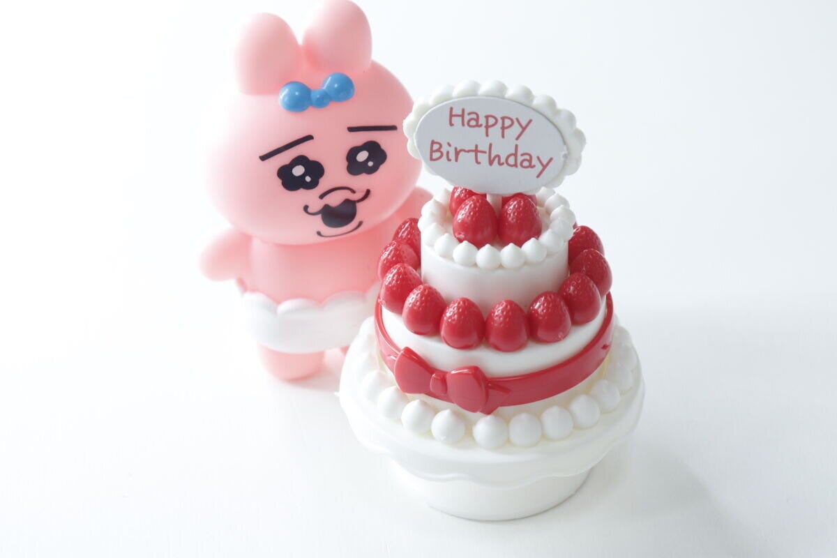 完成したケーキの横にピンク色のうさぎのぬいぐるみが置かれている