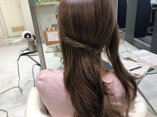分けた左サイドの毛束をねじって、右側の耳裏にピンで留める