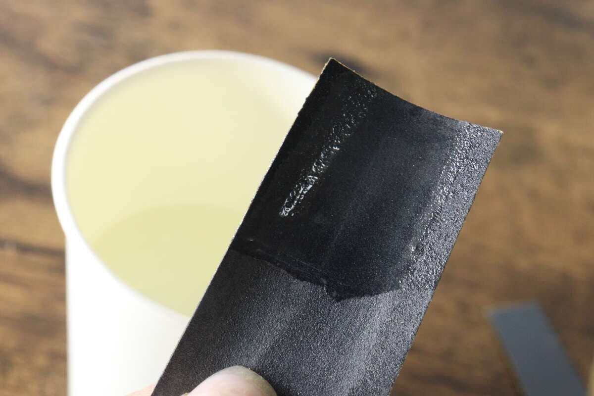 水に濡らして水研ぎの準備をしているサンドペーパーの表面のアップ 水に濡らして水研ぎの準備をしているサンドペーパーの表面のアップ