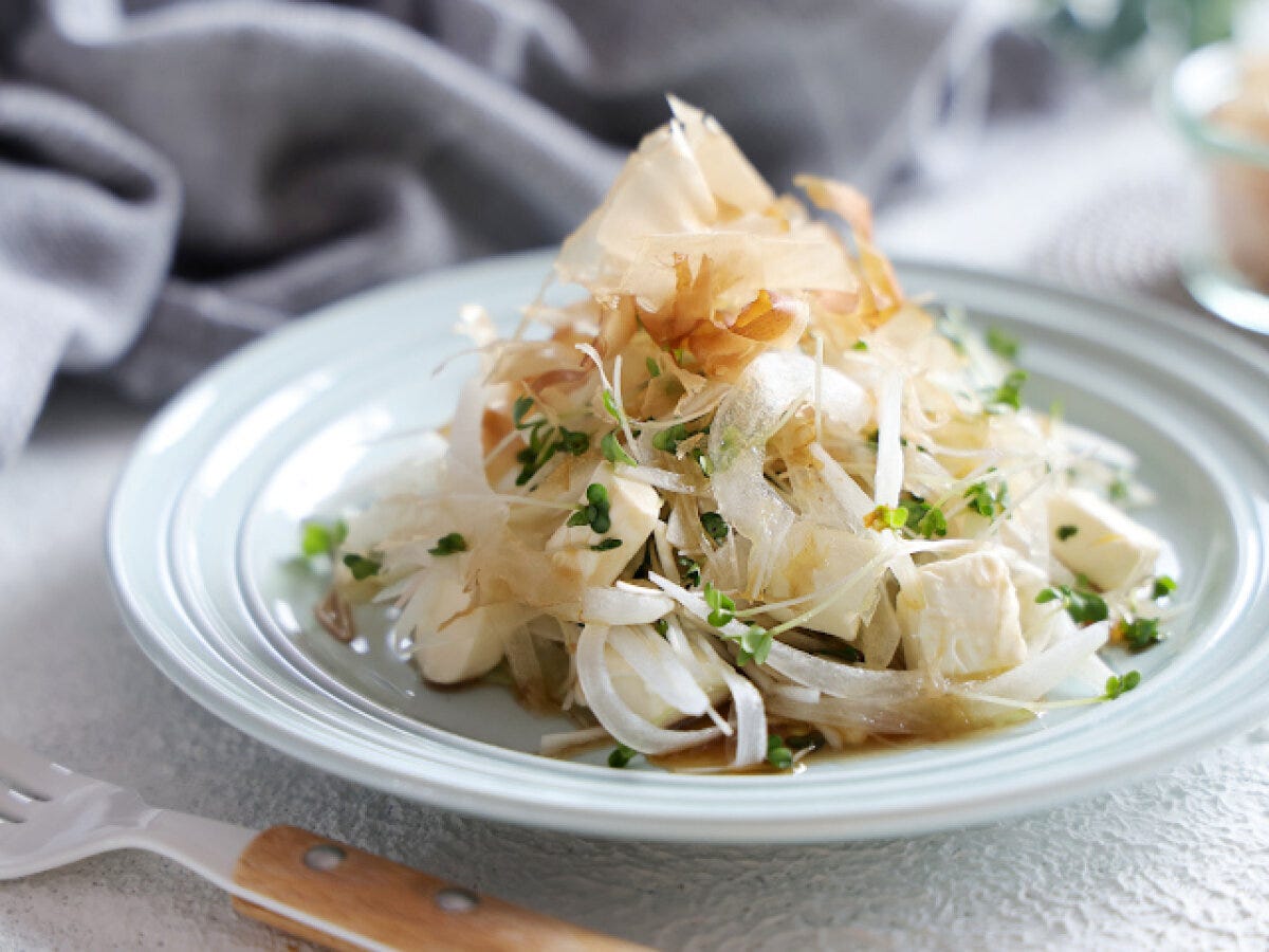 白い皿に盛り付けたおかかとクリームチーズの新玉ねぎサラダ 白い皿に盛り付けたおかかとクリームチーズの新玉ねぎサラダ