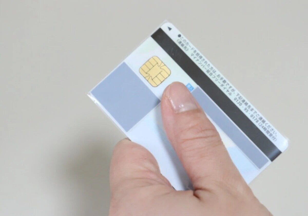マイナンバーカードにぴったりサイズの透明スリーブを装着している様子