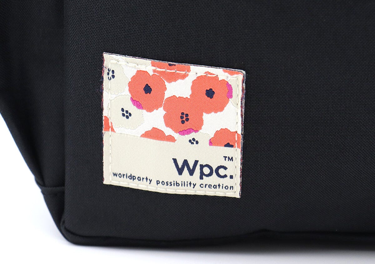 バッグ前面のWpc.ロゴとピオニ柄の織りタグのクローズアップ