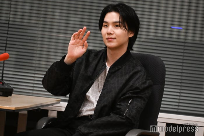 ラジオブースから手を振るSUGA(C)モデルプレス