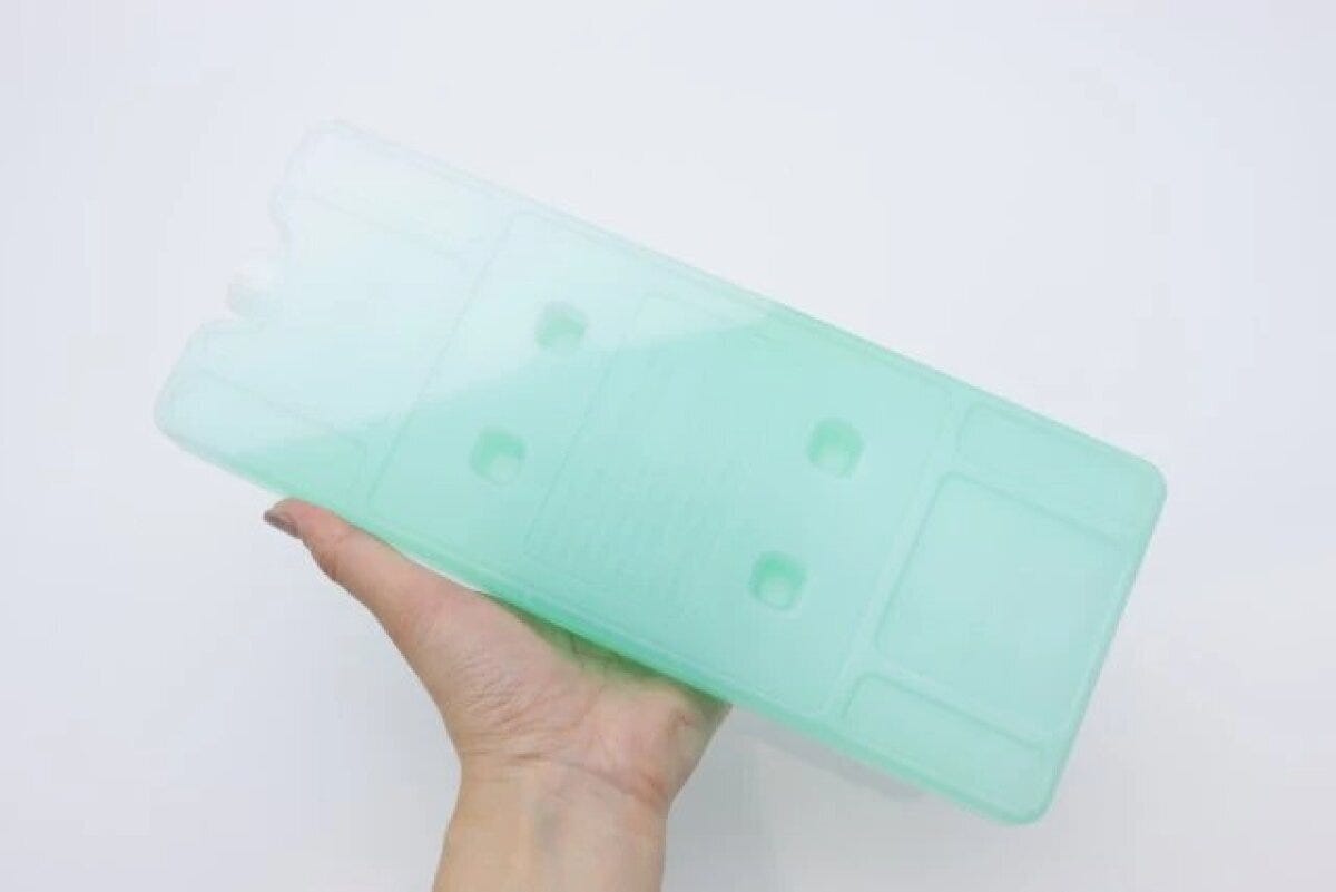 半透明の緑色のハードタイプ保冷剤を片手で持っている 半透明の緑色のハードタイプ保冷剤を片手で持っている