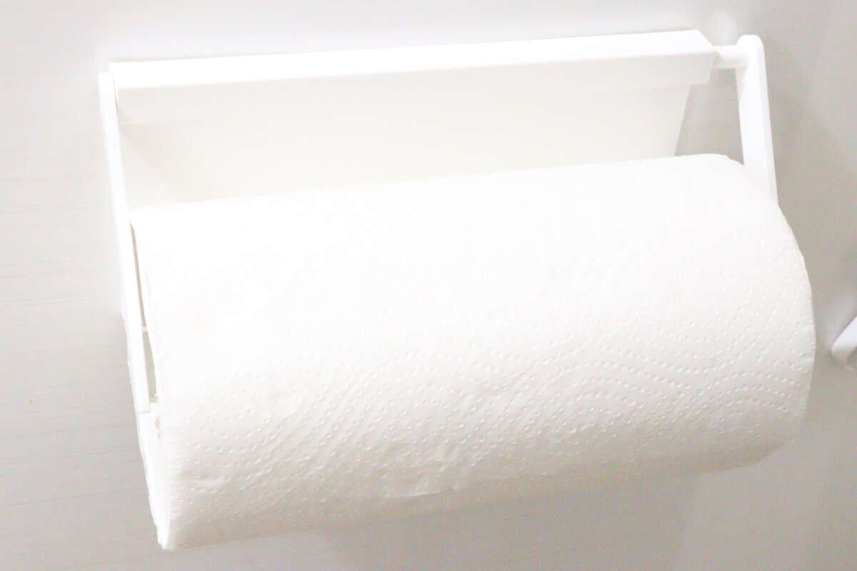 白いキッチンペーパーホルダーにセットされたロール状のキッチンペーパー 白いキッチンペーパーホルダーにセットされたロール状のキッチンペーパー