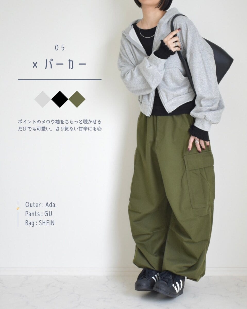 グレーのジップパーカーとカーキのパンツに黒の長袖トップスを合わせた女性