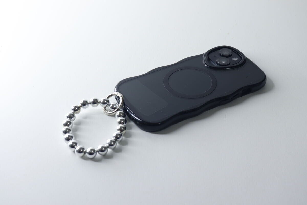 黒いスマホケースにシルバーのブレスレットストラップを装着