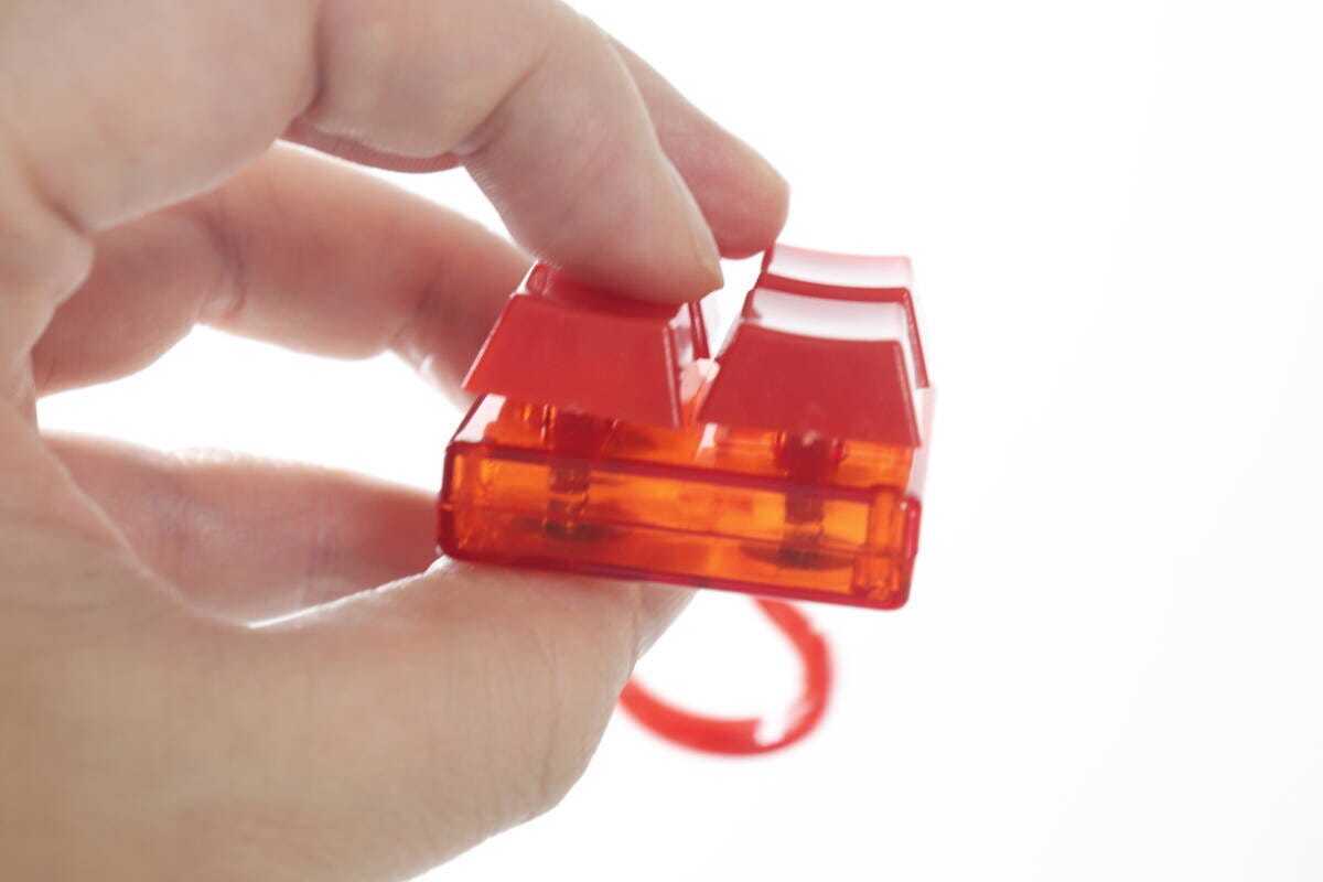 横から見たカラーブロックキーホルダーを指でつまんでいる様子 横から見たカラーブロックキーホルダーを指でつまんでいる様子