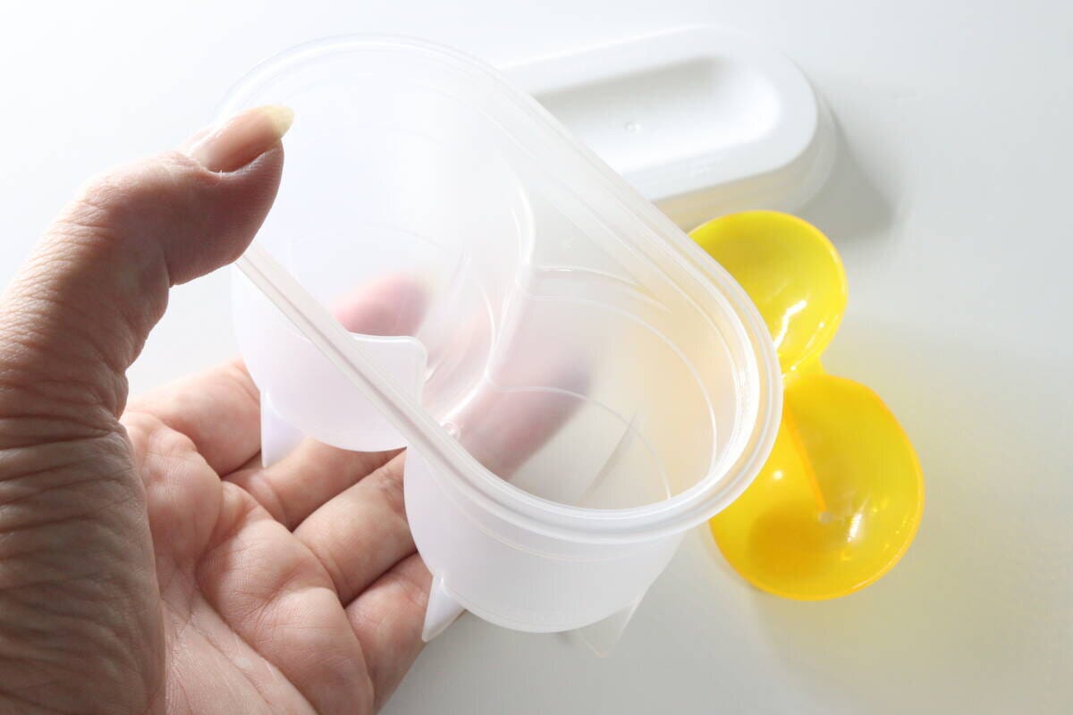 女性が味玉名人の容器から落とし蓋を外している様子 女性が味玉名人の容器から落とし蓋を外している様子
