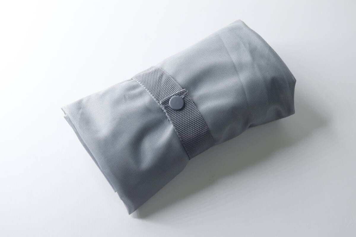 コンパクトに折りたたまれボタンで留められた洗濯バッグ