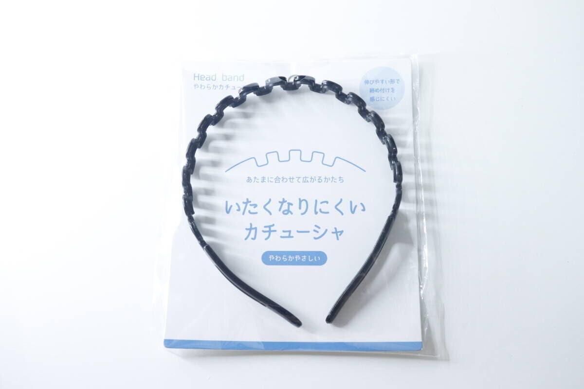 商品パッケージに入った黒いウェーブ状のカチューシャ。「いたくなくなりにくいカチューシャ」と書かれている。