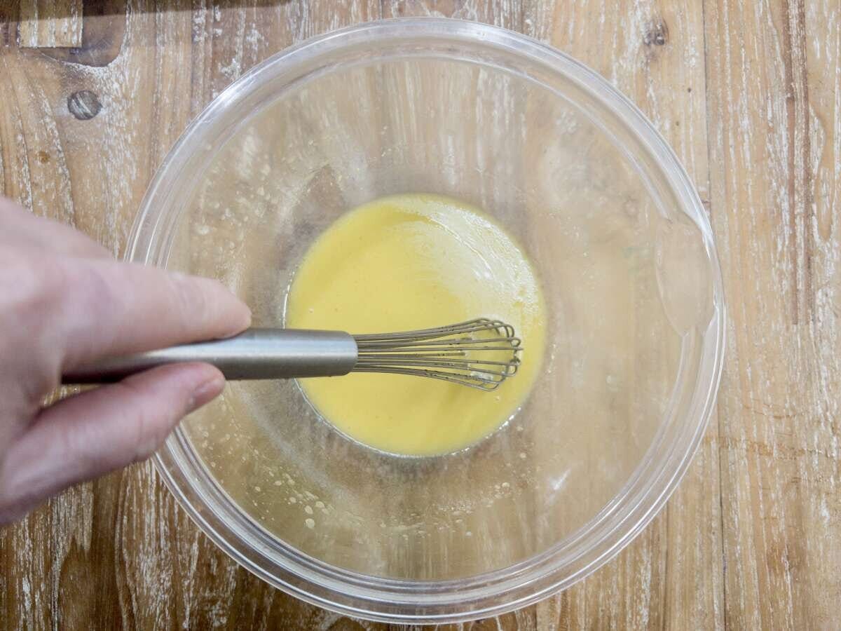 ガラスボウルの中のマリネ液をホイッパーで混ぜている工程の俯瞰写真