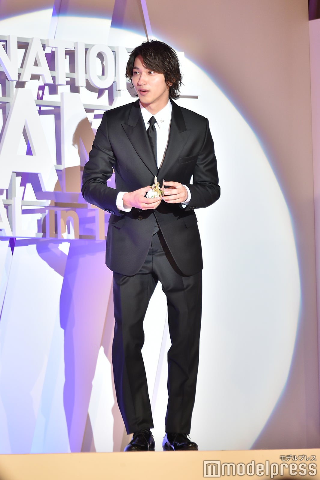 胸ポケットの花が落ちてしまい拾った横浜流星 （C）モデルプレス