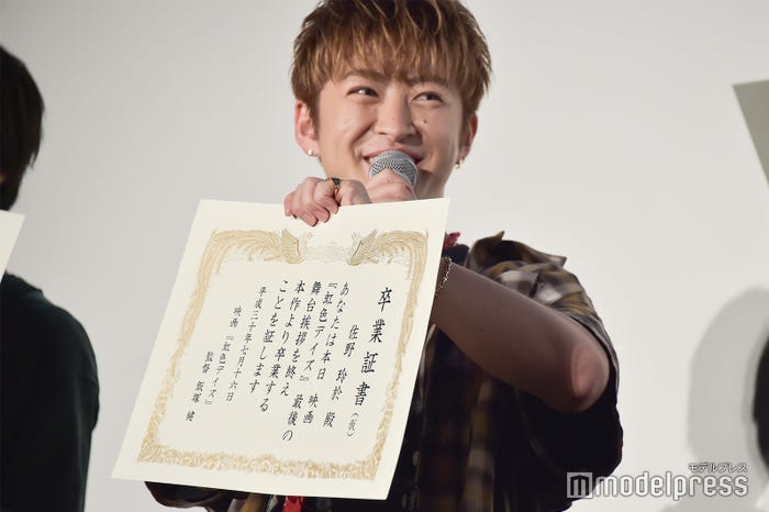卒業証書の「(仮)」の字を喜ぶ佐野玲於 (C)モデルプレス