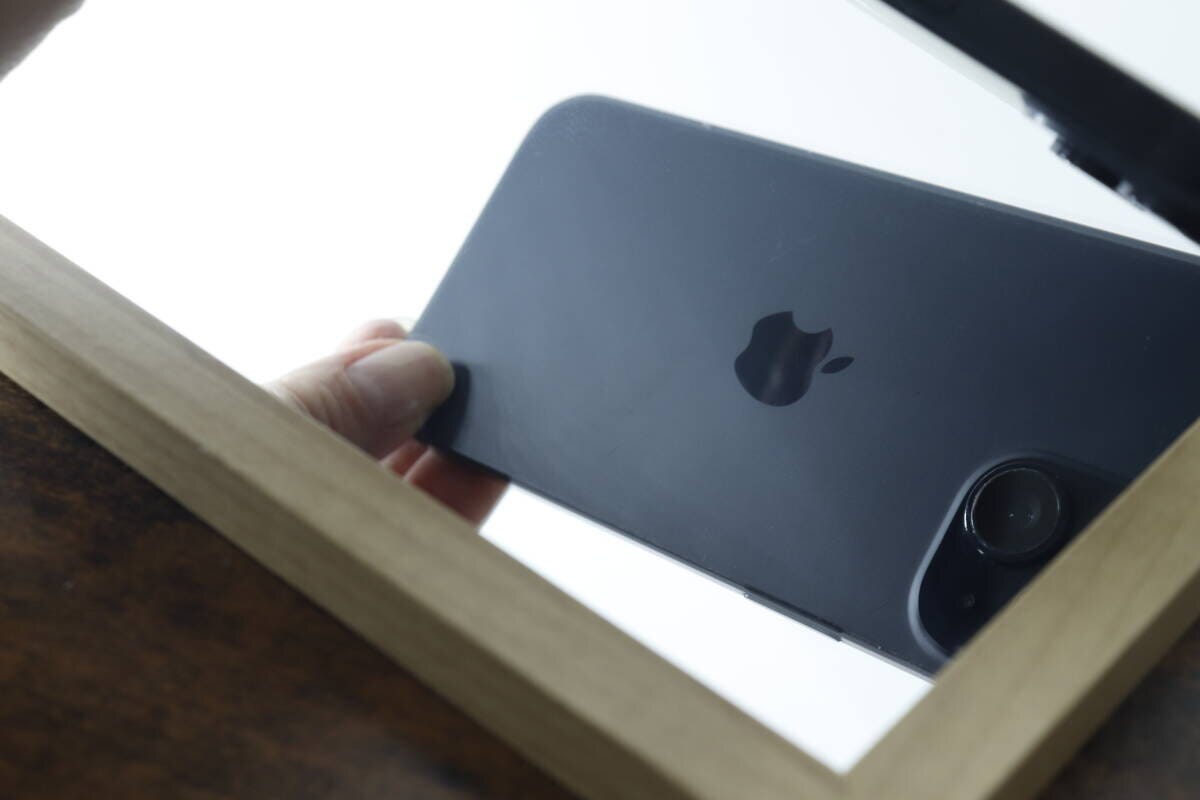 拭き取られてきれいになった鏡に映るスマートフォン