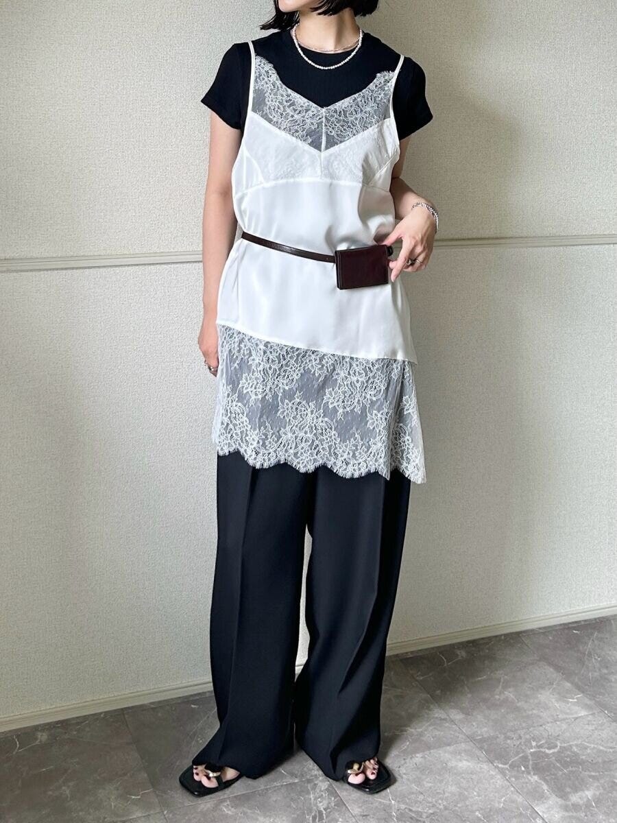 黒いリブミニTシャツの上に白いレースキャミソールを重ね着した女性の全身 黒いリブミニTシャツの上に白いレースキャミソールを重ね着した女性の全身