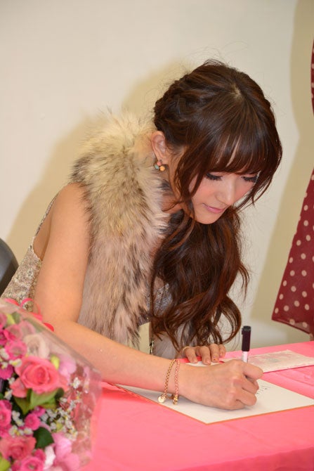 サインをする菅野結以