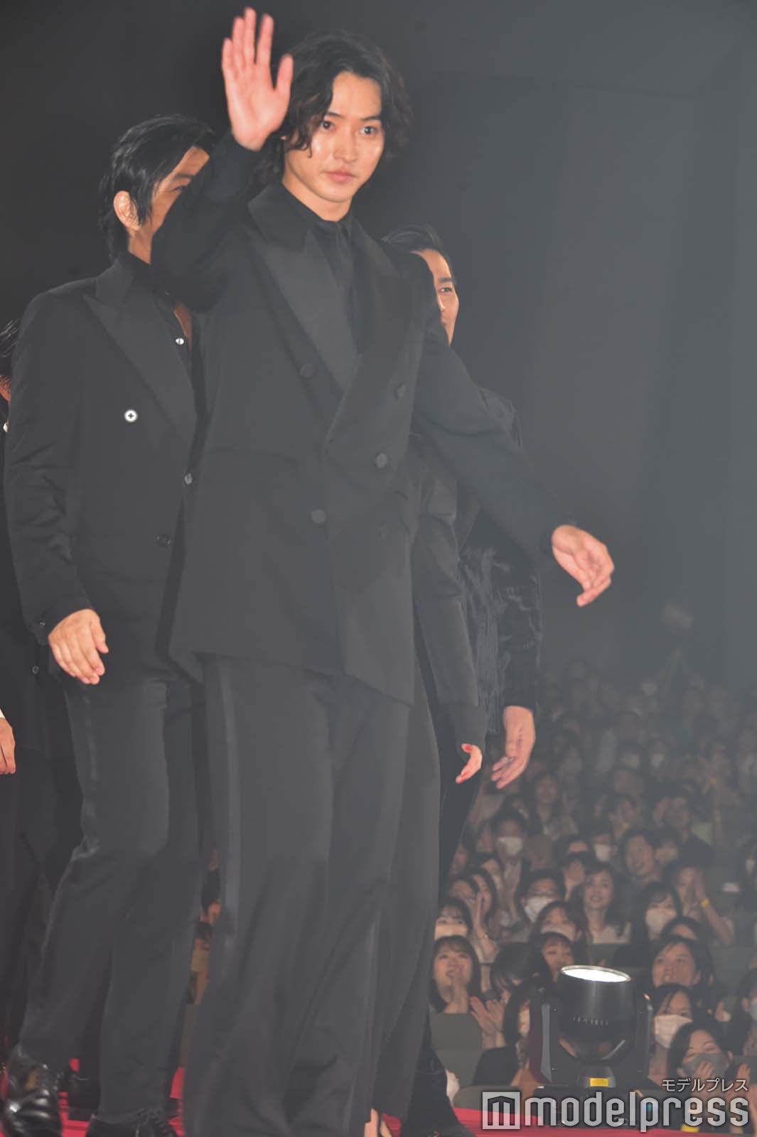 観客に手を振りランウェイを歩く山崎賢人