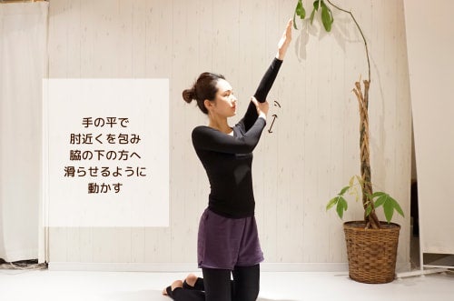 手の平で肘近くを包み脇の下の方へ滑らせるように動かす