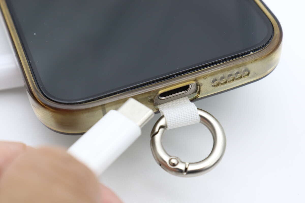 スマホケースに装着したまま充電器を挿し込んでいる手元