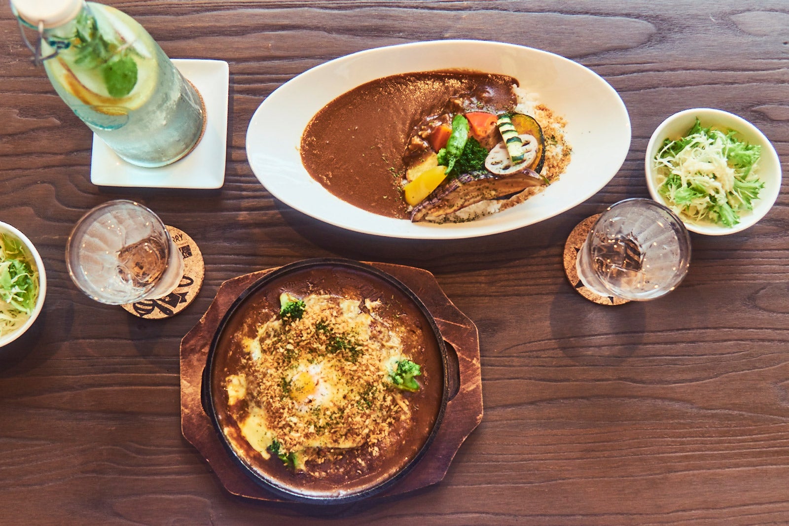 季節の有機野菜をふんだんに使用した旬野菜カレー（上）と、オールドファッションな自慢のスパイシー焼きカレー（下）（C）モデルプレス