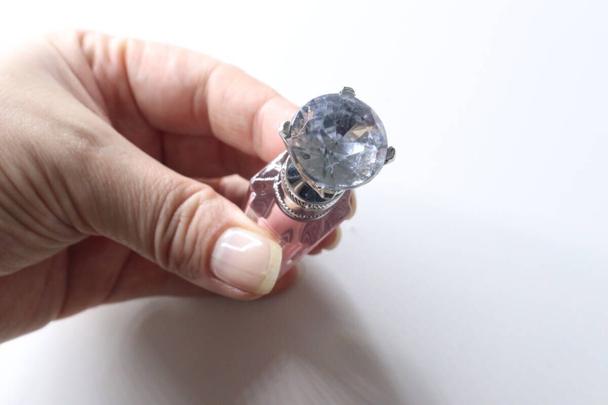 女性の手が宝石のようなキャップのリッププランパーを持っている 女性の手が宝石のようなキャップのリッププランパーを持っている