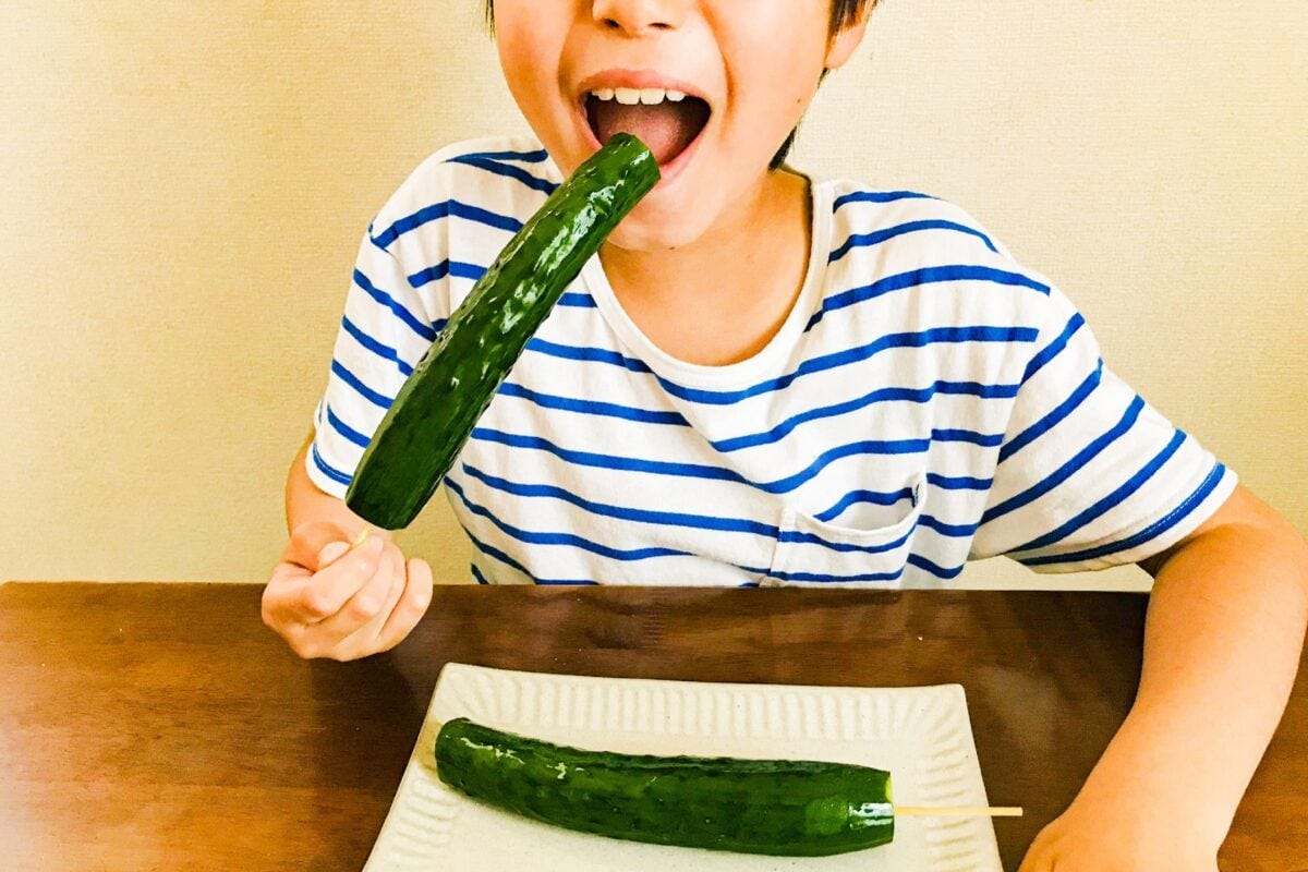 きゅうりを食べる小学生