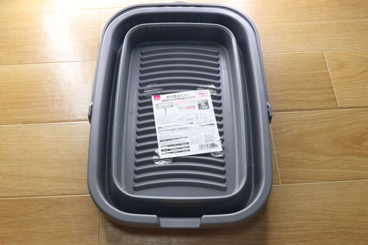 折り畳まれた状態のグレーのたらい。中央に商品ラベルが貼られている。 折り畳まれた状態のグレーのたらい。中央に商品ラベルが貼られている。