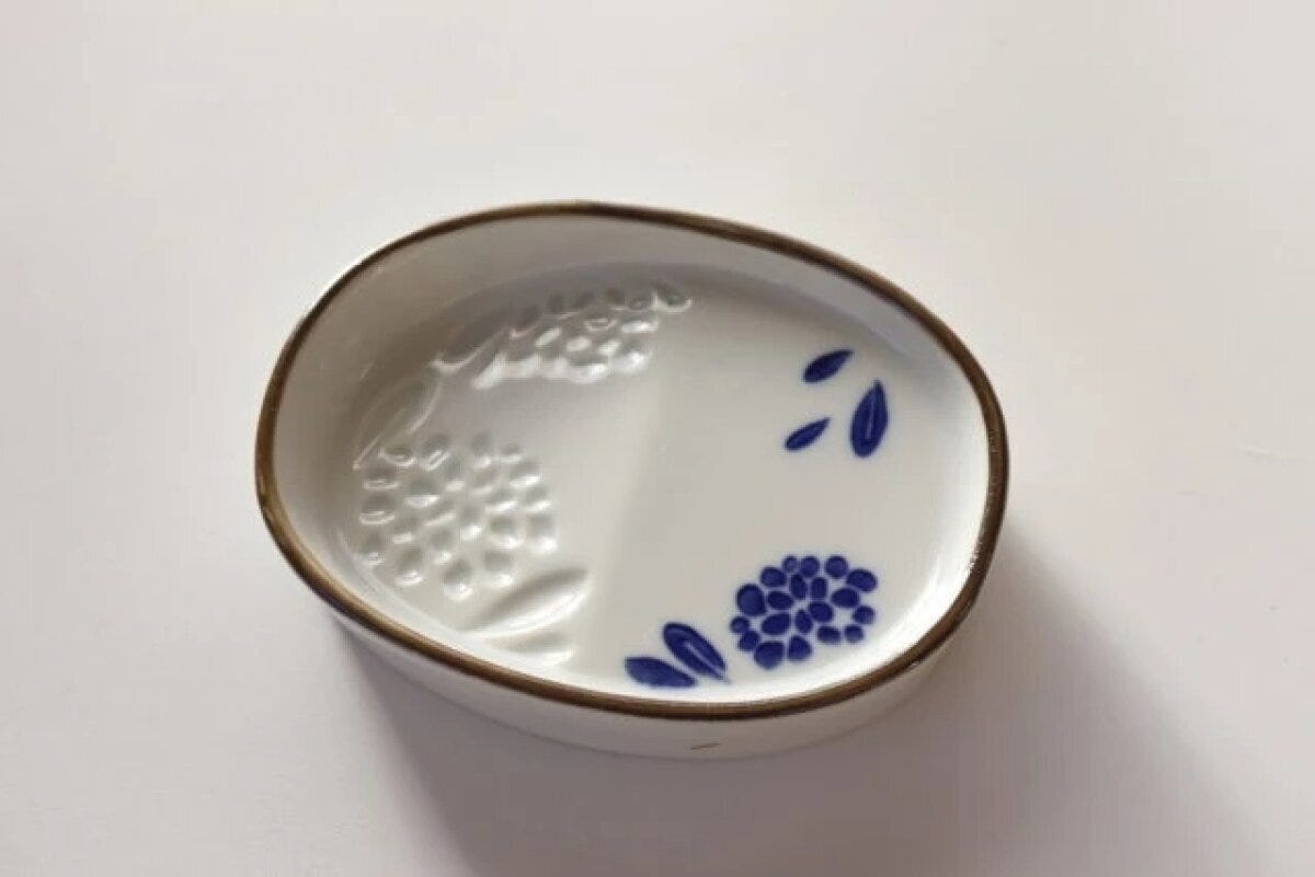 白い楕円形のななめ醤油皿が斜め上から写っている 白い楕円形のななめ醤油皿が斜め上から写っている