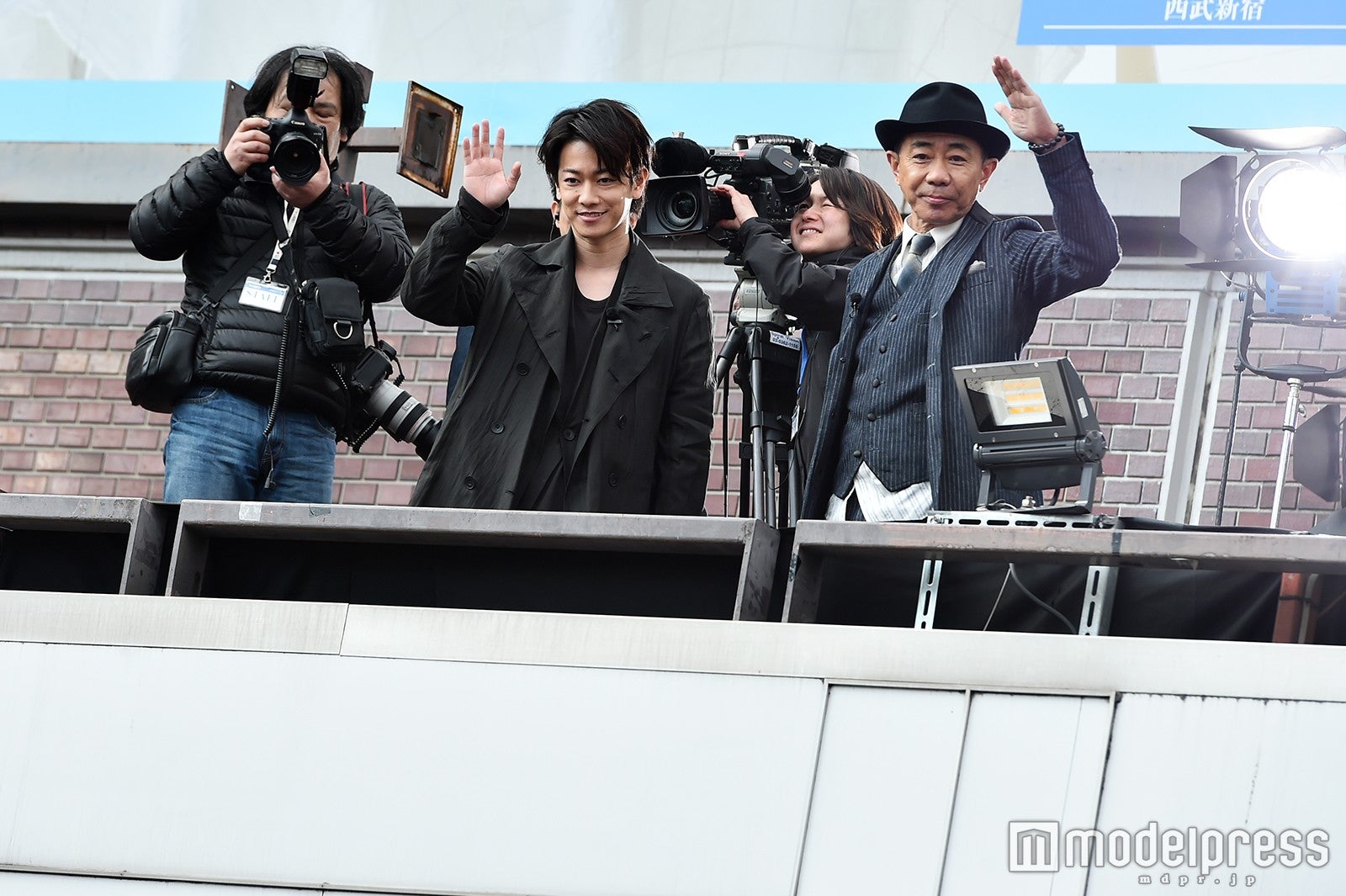 集まった新宿の人々に手を振る佐藤健、木梨憲武 （C）モデルプレス