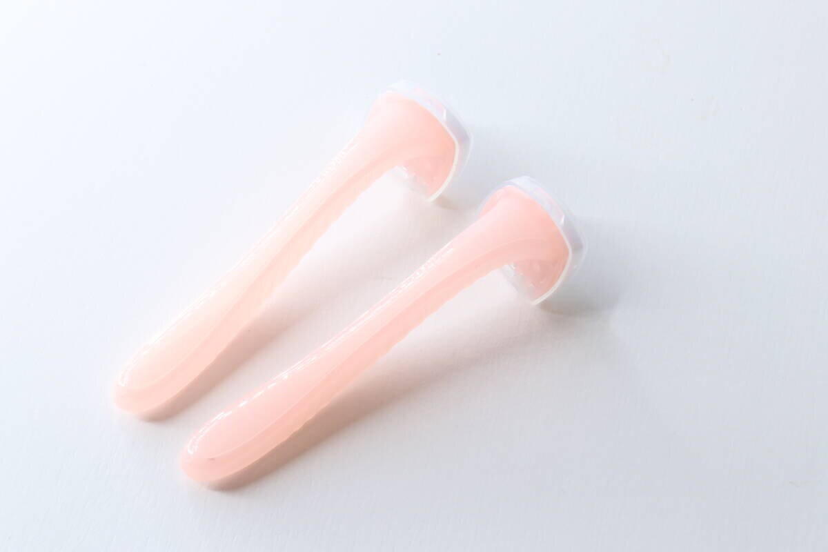 ピンク色のビキニライン用カミソリ2本が白い背景に並べられている ピンク色のビキニライン用カミソリ2本が白い背景に並べられている