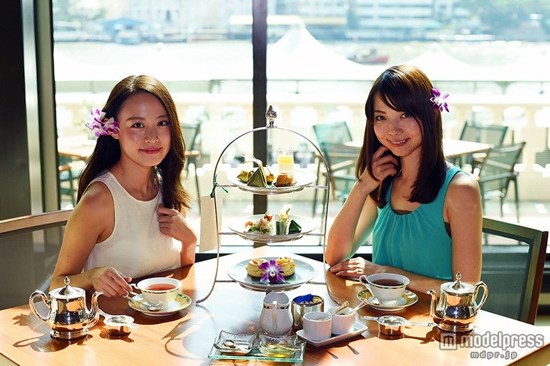 ガラス張りの向こうにバンコクの街を眺められる「ザ・ロビー」／モデル：富田千穂、三好利奈