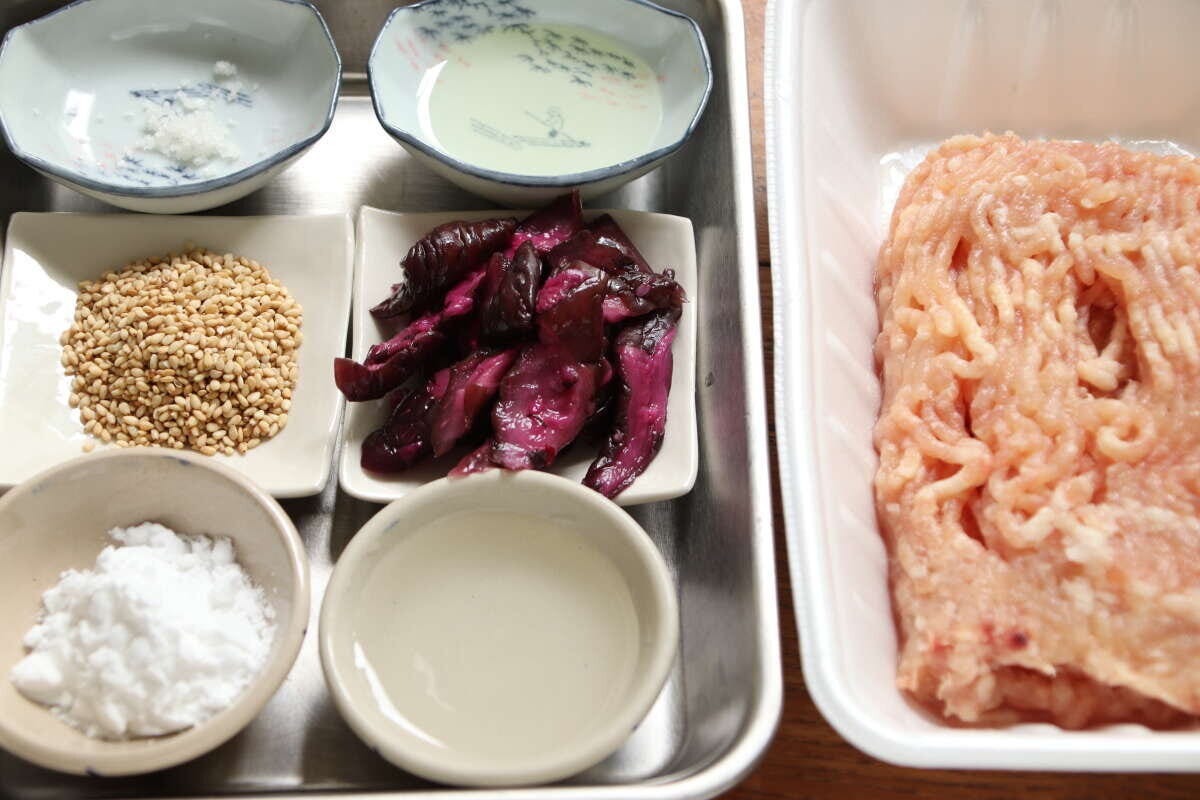 ステンレスのトレーに鶏ひき肉、しば漬け、白ごま、酒、片栗粉、油が小皿に分けられて並べられた材料の俯瞰写真