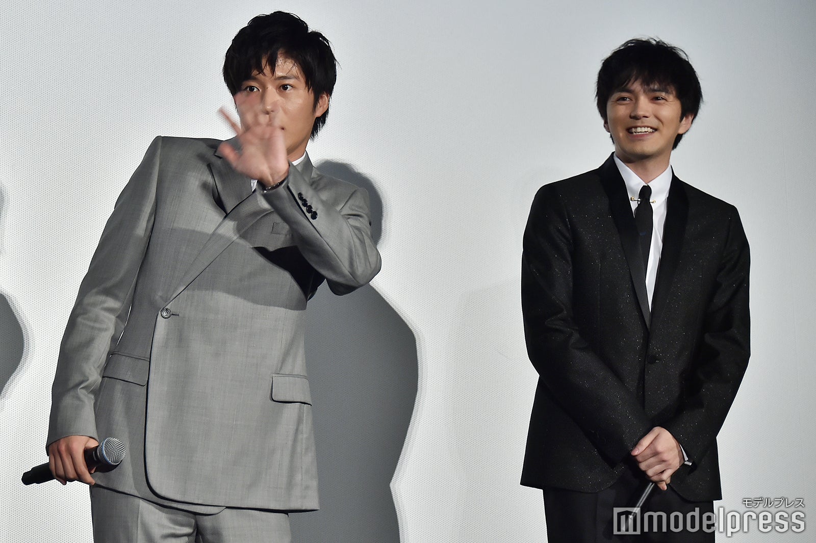 ライブビューイングのカメラを林遣都（右）に教えてもらい手をふる田中圭（左）／（C）モデルプレス