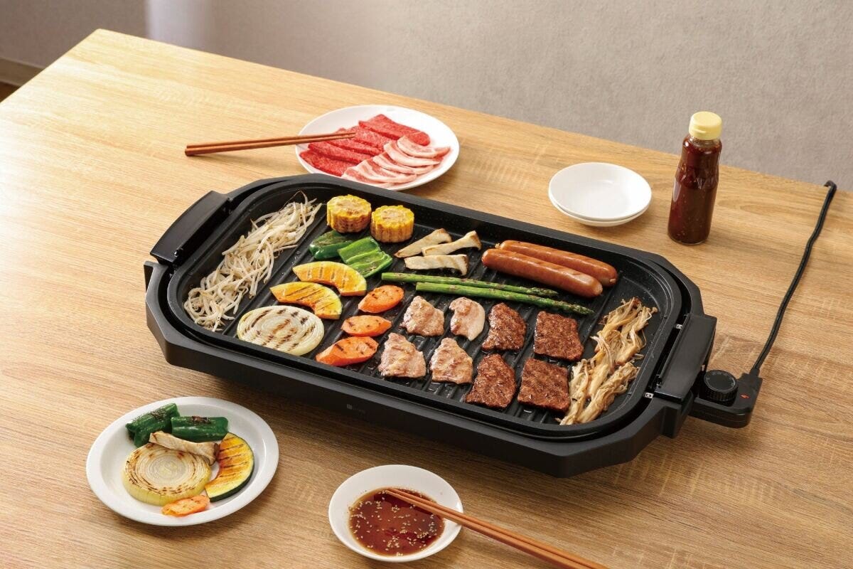 波型プレートで肉や野菜、ソーセージが焼かれ、タレと取り皿が並ぶ