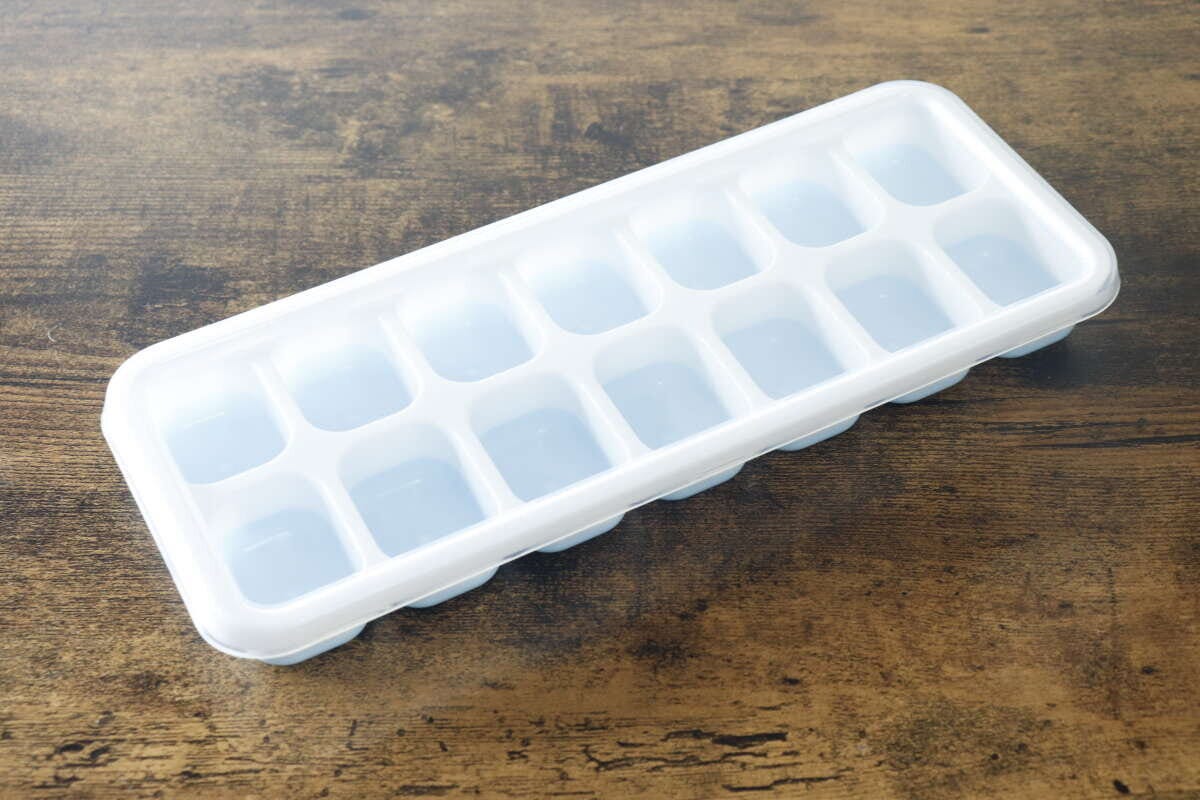 パッケージから出した状態のセリアの氷が取り出しやすい蓋付きアイストレーが木目のテーブルに置かれている パッケージから出した状態のセリアの氷が取り出しやすい蓋付きアイストレーが木目のテーブルに置かれている