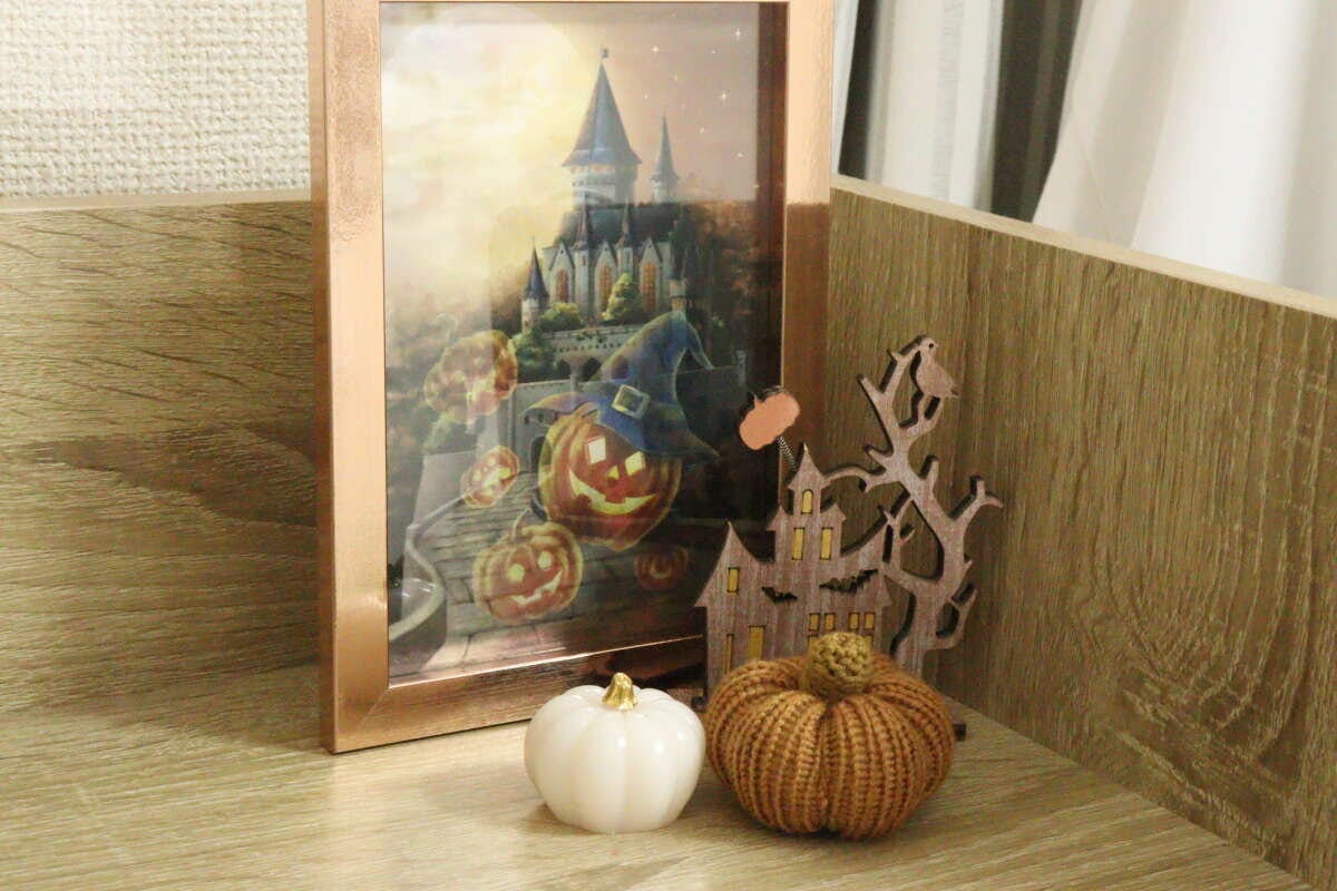 額縁に入れたレンチキュラーアートとウッドハロウィンハウススタンドを並べて飾った様子
