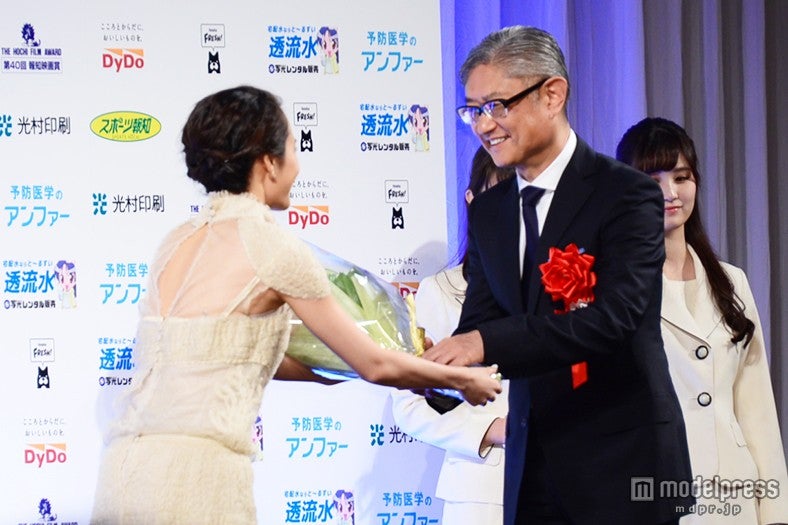 堤幸彦監督（右）に花束を贈呈する前田敦子（左）