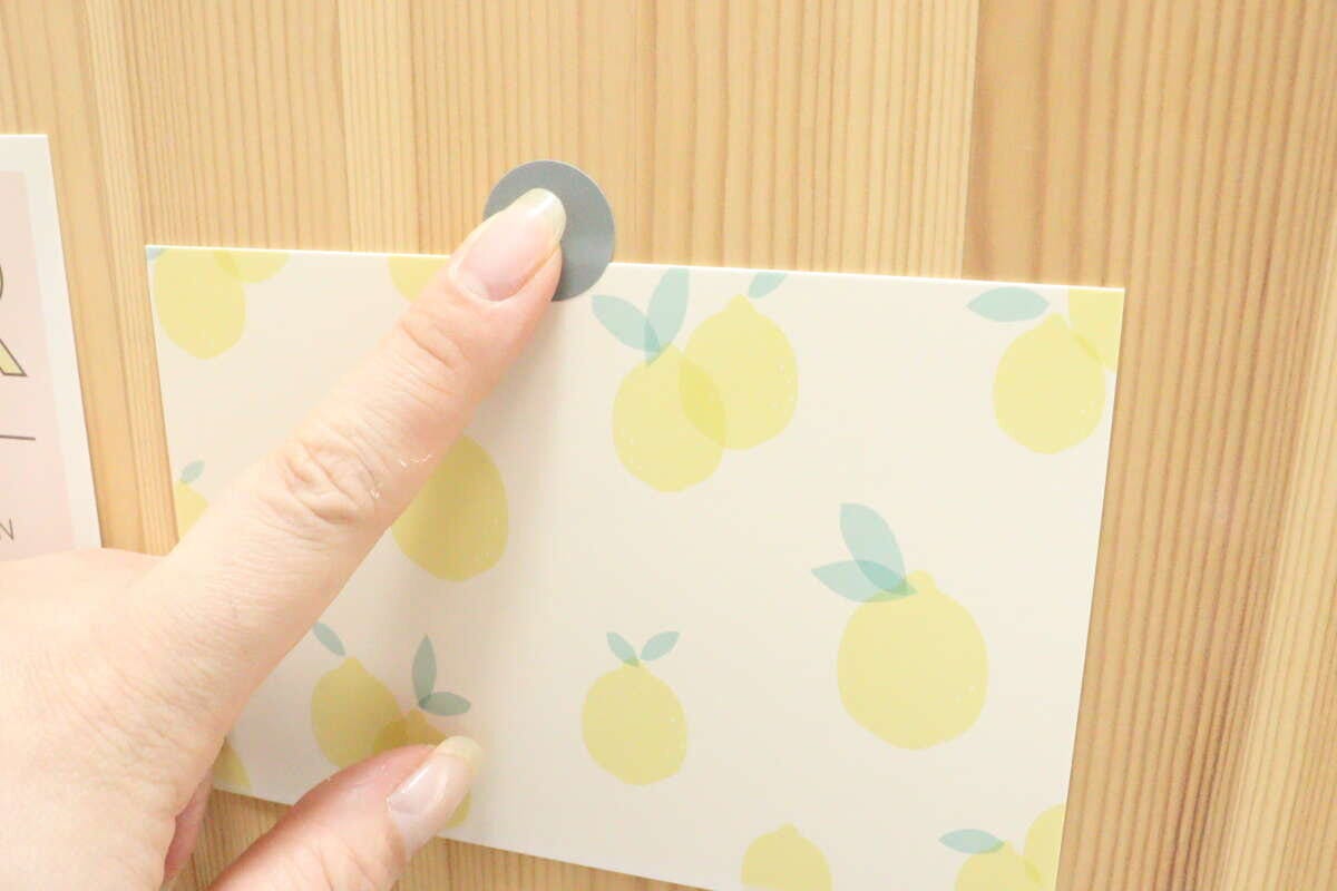 レモン柄のカードを壁にシールで貼る様子 レモン柄のカードを壁にシールで貼る様子