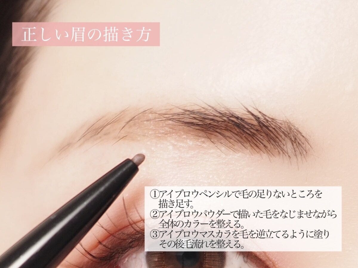 アイブロウペンシルで毛の足りない部分を描き足している女性の眉のアップ