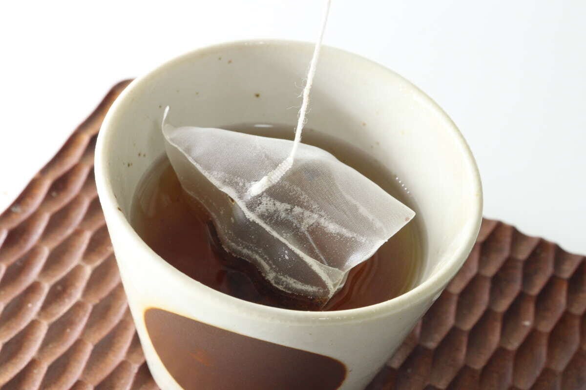 白い湯呑み茶碗にティーバッグが浸されお茶を淹れている様子 白い湯呑み茶碗にティーバッグが浸されお茶を淹れている様子