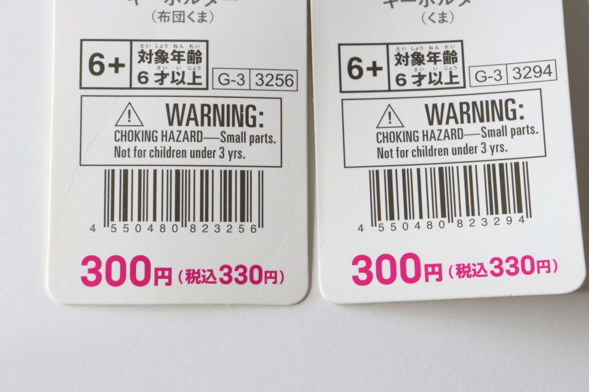 ダイソーのキーホルダーのタグの裏面。対象年齢やバーコード、価格が写っている ダイソーのキーホルダーのタグの裏面。対象年齢やバーコード、価格が写っている