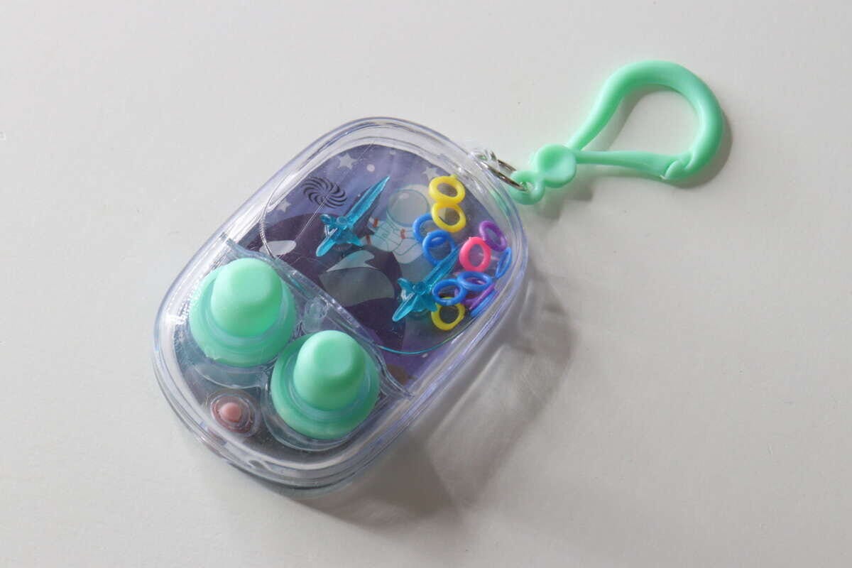 白い背景に置かれた、水色のボタンが付いた楕円形のミニウォーターゲーム機 白い背景に置かれた、水色のボタンが付いた楕円形のミニウォーターゲーム機