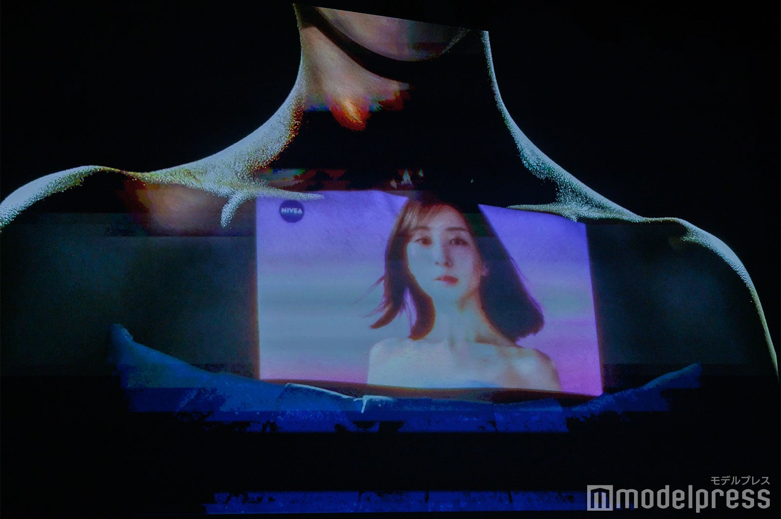 デコルテに投影されたCM（C）モデルプレス