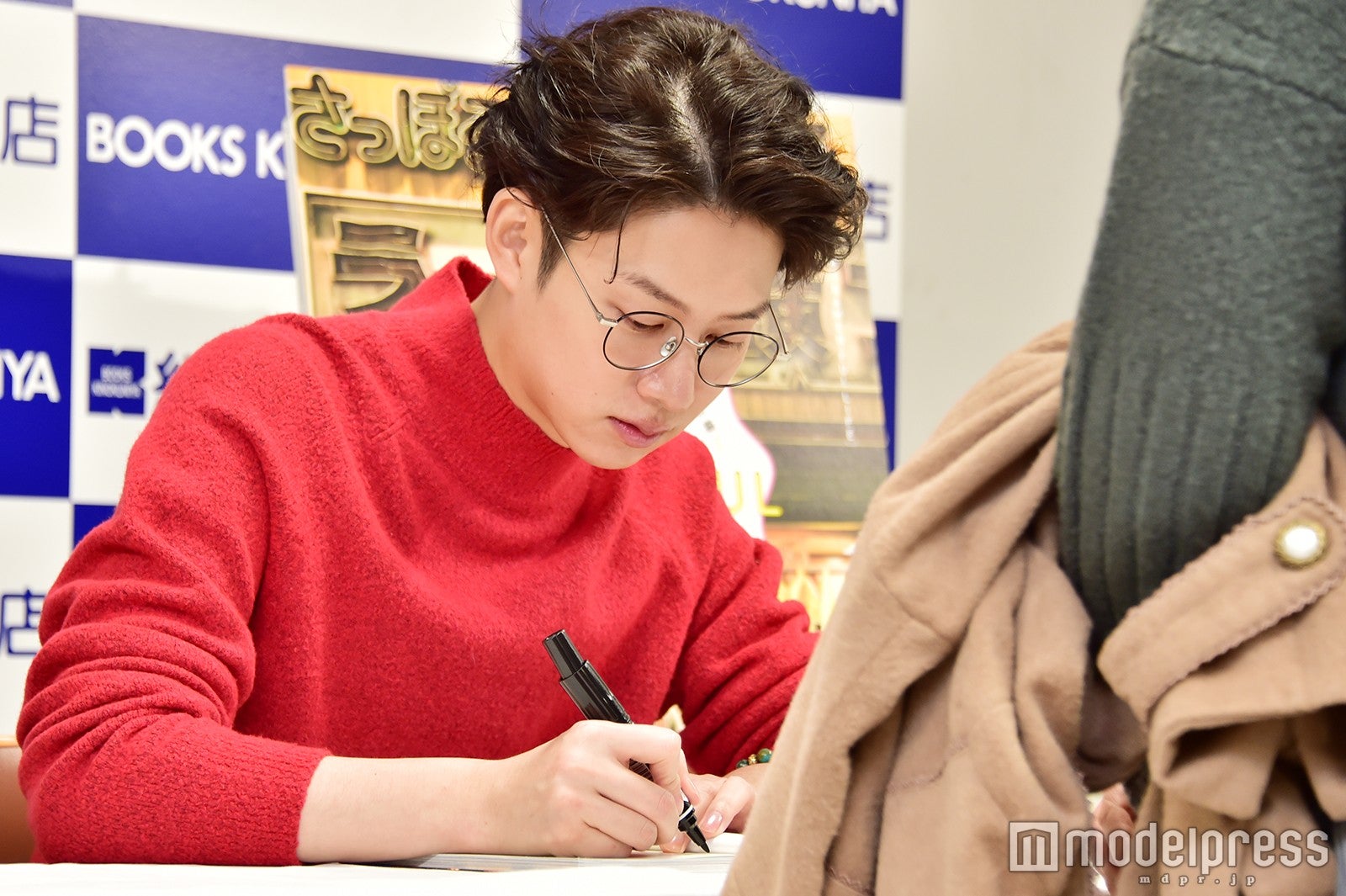 ていねいにサインを書く（C）モデルプレス