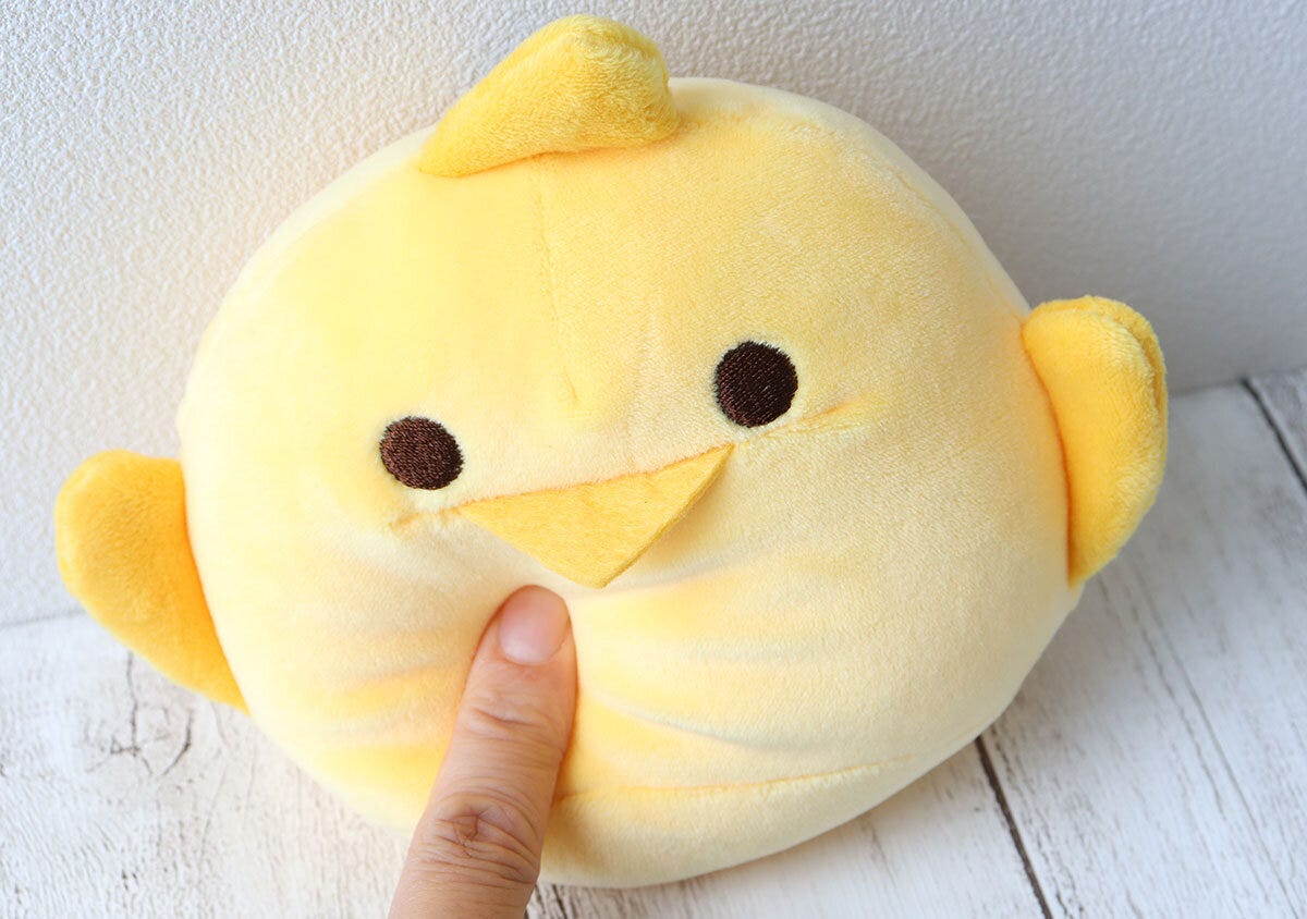 ぴよりんぬいぐるみチャームを指で押して感触を確かめている ぴよりんぬいぐるみチャームを指で押して感触を確かめている